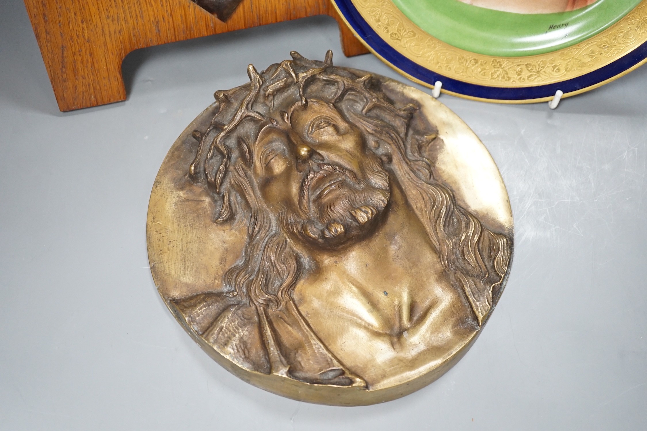 A Limoges plate and cast bronze portrait of Christ with crown of thorns and a framed plaque of the Madonna, frame 37 cms high